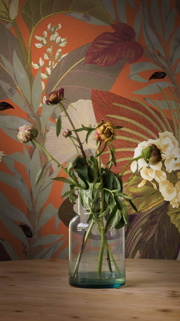 Styled interior detail featuring The Rowan wallcover with decorative flowers and contemporary accessories.